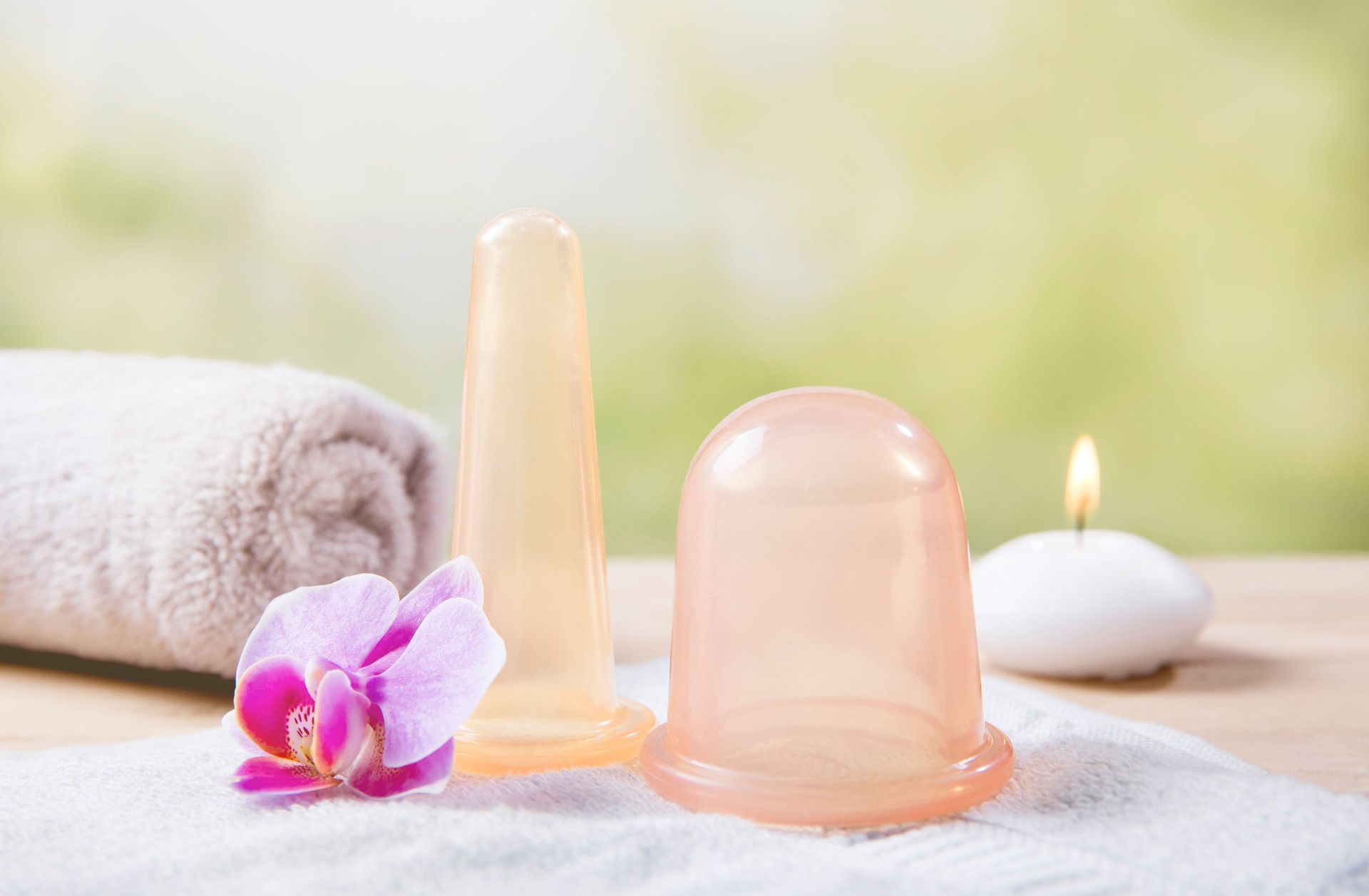 Remove body cellulite using big silicone massaging cupping tool, increases blood flow in skin tissue. Smooth skin with smaller face cupping tool. Still life studio composition.